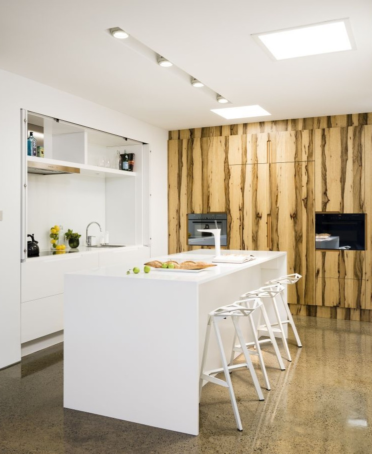Photo of a small contemporary l-shaped separate kitchen in Melbourne with flat-panel cabinets, white cabinets and with island.
