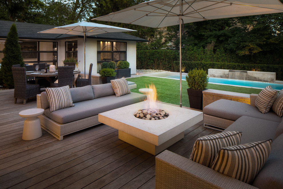 Design ideas for a large contemporary backyard patio in Toronto with a fire feature, decking and no cover.