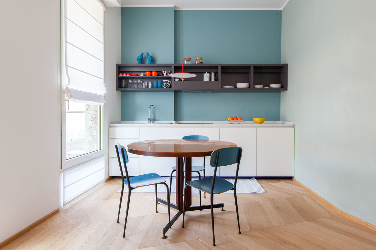Design ideas for a small contemporary single-wall eat-in kitchen in Milan with a drop-in sink, flat-panel cabinets, white cabinets, medium hardwood floors, no island, beige floor, granite benchtops, blue splashback and panelled appliances.