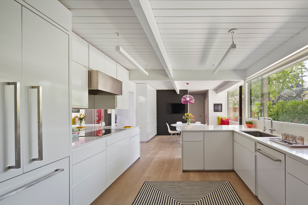 Example of a 1950s eat-in kitchen design in San Francisco with a single-bowl sink, flat-panel cabinets, white cabinets and paneled appliances