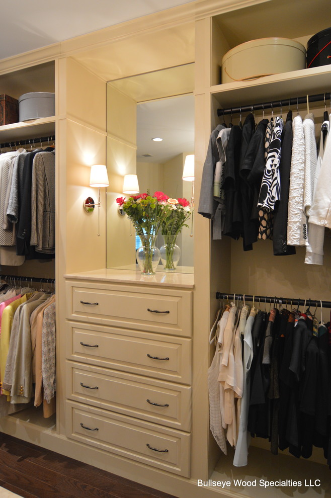 Large traditional women's walk-in wardrobe in DC Metro with raised-panel cabinets, white cabinets and dark hardwood floors.