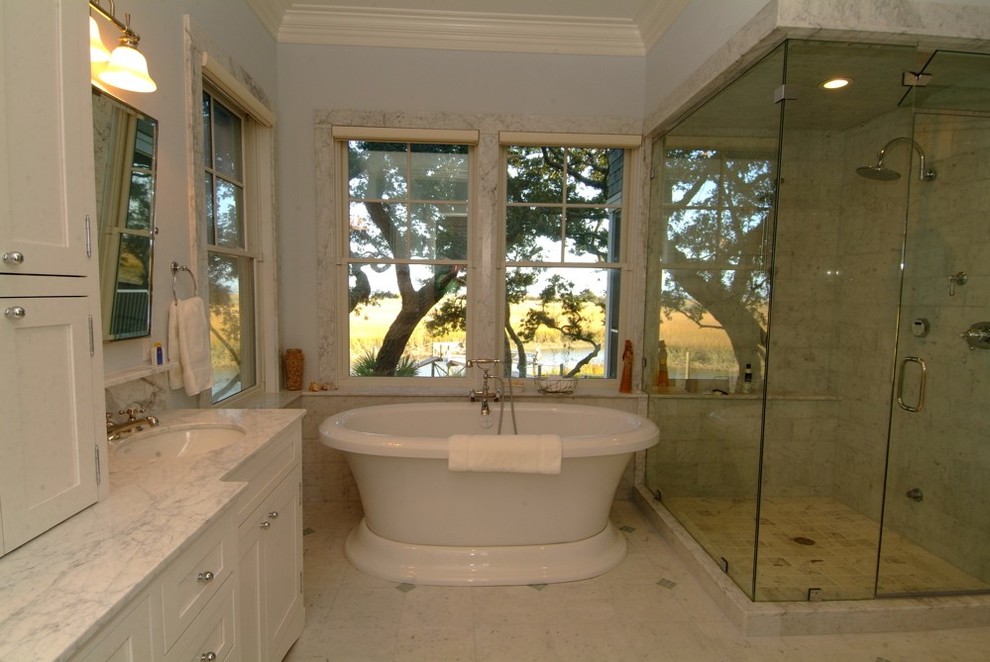 Large transitional white floor and double-sink freestanding bathtub photo in Charleston with white cabinets, blue walls, an undermount sink, a hinged shower door and white countertops