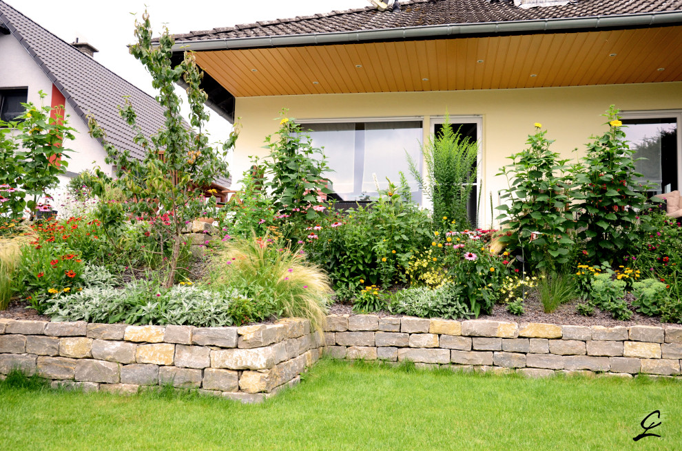 Foto de jardín clásico de tamaño medio en verano en patio lateral con exposición parcial al sol y adoquines de piedra natural