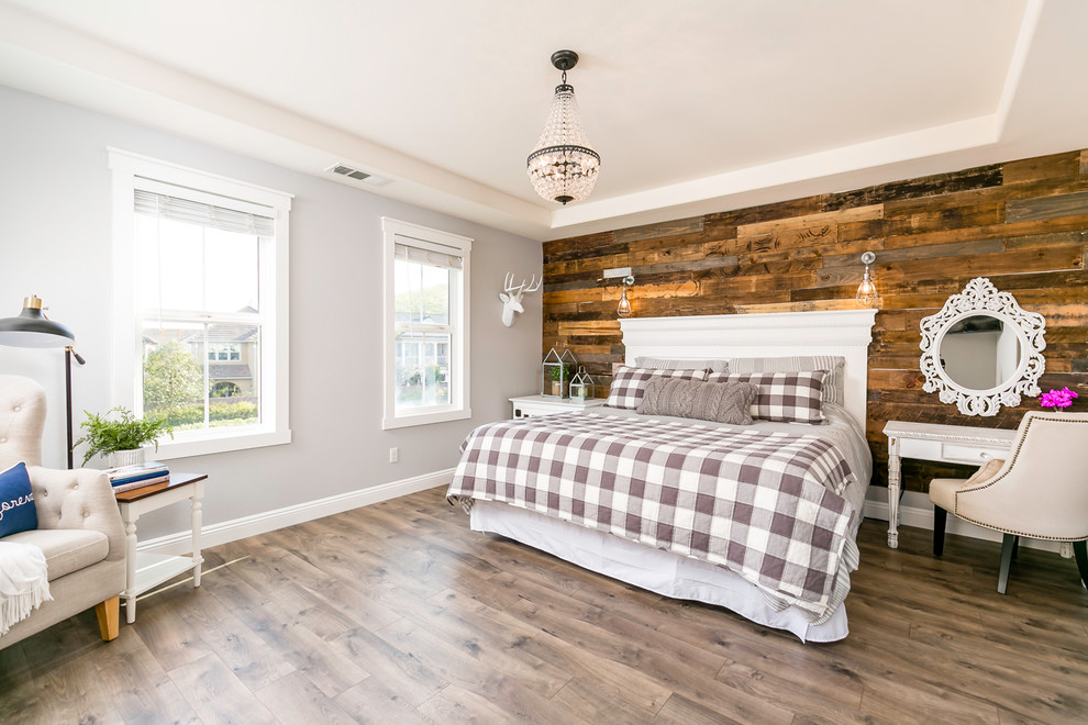 This is an example of a large country master bedroom in Dallas with grey walls, laminate floors and brown floor.