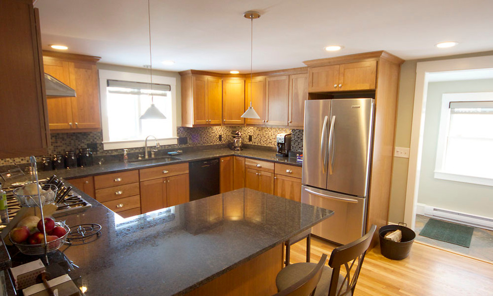 Inspiration for a mid-sized transitional u-shaped medium tone wood floor eat-in kitchen remodel in Boston with an undermount sink, shaker cabinets, medium tone wood cabinets, granite countertops, multicolored backsplash, glass tile backsplash, stainless steel appliances and a peninsula