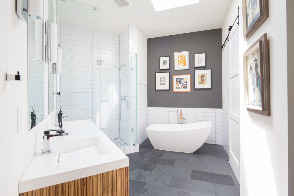 Transitional master bathroom in Denver with white tile, grey walls, grey floor, a hinged shower door, brown cabinets, a freestanding tub, an alcove shower and an integrated sink.