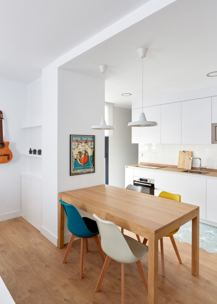 Imagen de comedor moderno de tamaño medio abierto con paredes blancas y suelo de madera clara