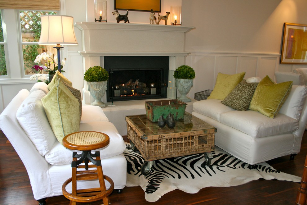 This is an example of a beach style living room in Los Angeles with white walls, dark hardwood floors and a standard fireplace.