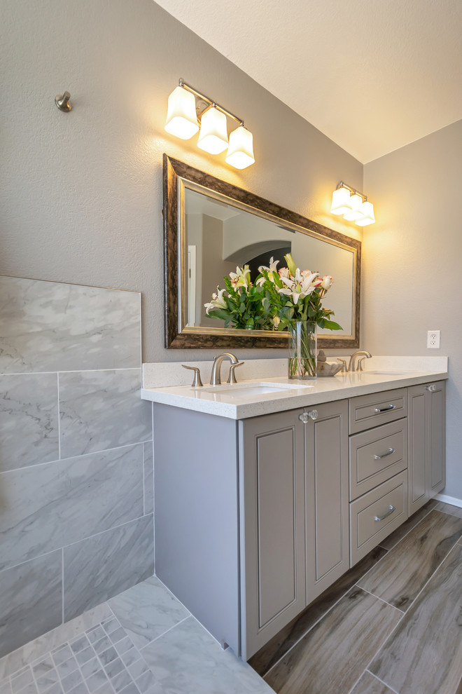 Photo of a mid-sized transitional master bathroom in Phoenix with raised-panel cabinets, grey cabinets, an open shower, gray tile, porcelain tile, grey walls, porcelain floors, a drop-in sink, engineered quartz benchtops, grey floor, an open shower and white benchtops.