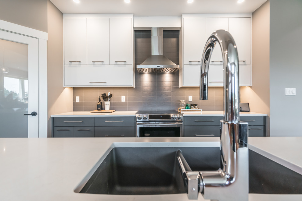 This is an example of a mid-sized modern single-wall open plan kitchen in Other with a double-bowl sink, shaker cabinets, grey cabinets, grey splashback, stainless steel appliances, medium hardwood floors, with island, brown floor and white benchtop.