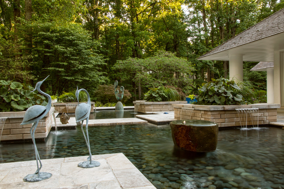 Inspiration for a mid-sized contemporary backyard patio in DC Metro with natural stone pavers and a pergola.