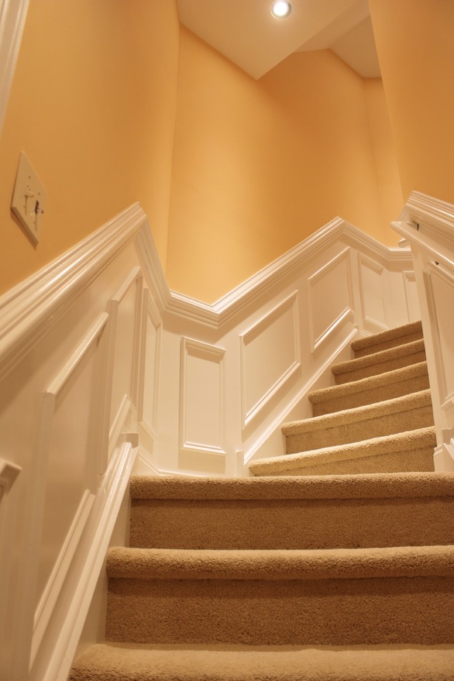 Photo of a mid-sized traditional carpeted floating staircase in Philadelphia with carpet risers and wood railing.