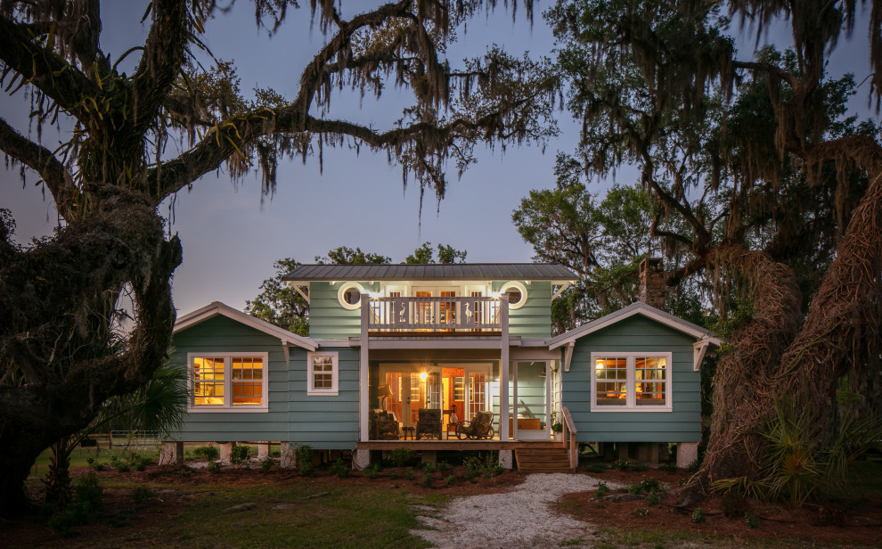 Design ideas for a mid-sized country two-storey blue house exterior in Tampa with wood siding, a gable roof, a metal roof, a grey roof and clapboard siding.