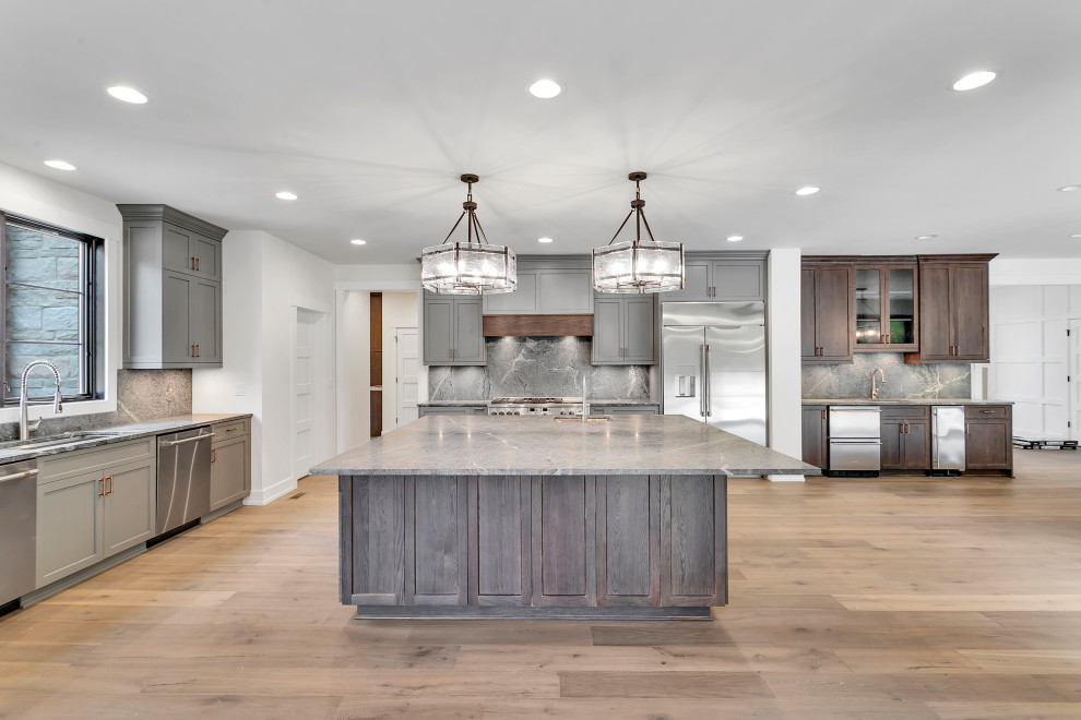 Eat-in kitchen - huge rustic l-shaped medium tone wood floor, multicolored floor and wood ceiling eat-in kitchen idea with an undermount sink, recessed-panel cabinets, gray cabinets, soapstone countertops, gray backsplash, quartz backsplash, stainless steel appliances, an island and gray countertops