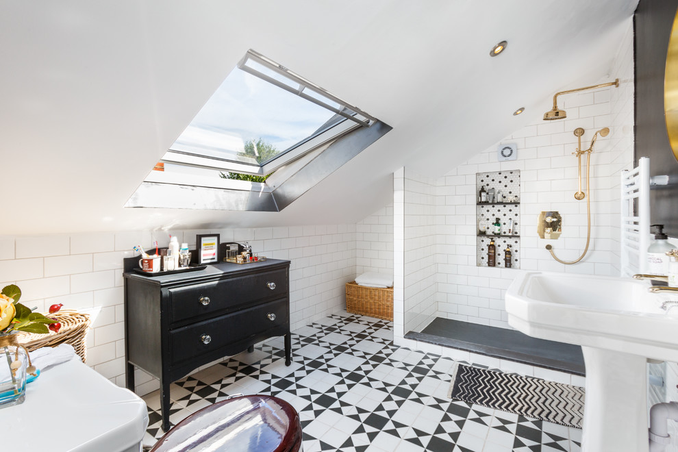 This is an example of a scandinavian bathroom in London with black cabinets, an alcove shower, white tile, subway tile, white walls, a pedestal sink, multi-coloured floor and raised-panel cabinets.