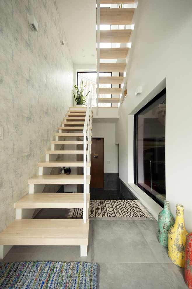 Design ideas for a contemporary wood u-shaped staircase in Tokyo with open risers and metal railing.