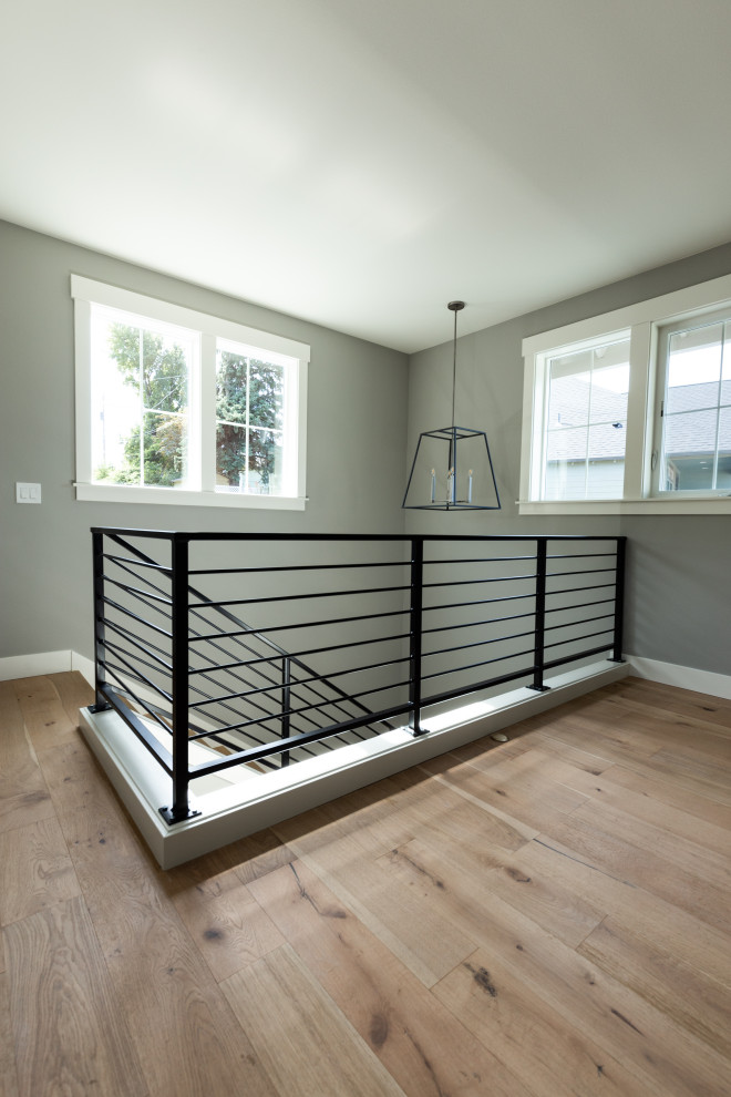 This is an example of a large country wood l-shaped staircase in Portland with wood risers and metal railing.