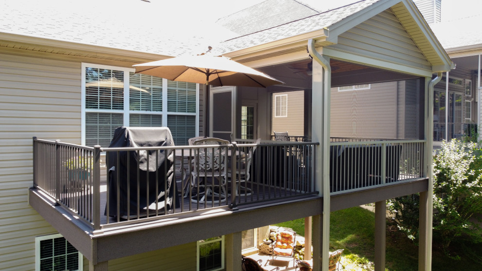 Diseño de terraza pequeña en patio trasero y anexo de casas con barandilla de metal
