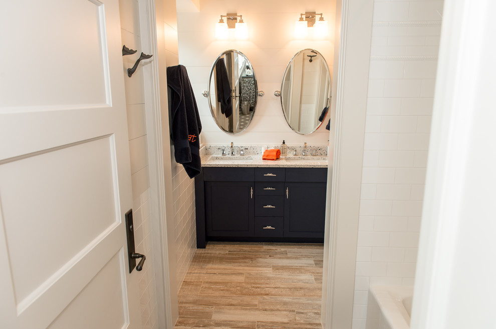 Design ideas for a mid-sized traditional kids bathroom in Charleston with furniture-like cabinets, blue cabinets, an alcove tub, a shower/bathtub combo, multi-coloured tile, subway tile, white walls, porcelain floors, an undermount sink and recycled glass benchtops.