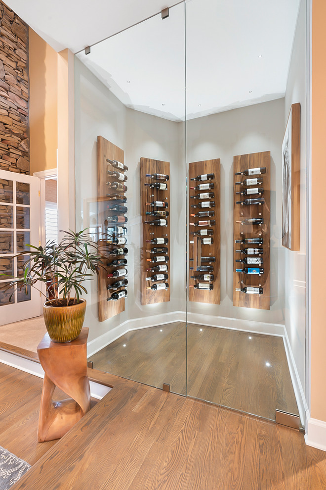 This is an example of a contemporary wine cellar in Atlanta with medium hardwood floors, display racks and brown floor.