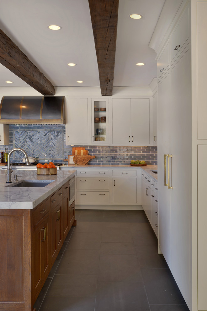 This is an example of an expansive transitional l-shaped eat-in kitchen in New York with an undermount sink, flat-panel cabinets, white cabinets, quartzite benchtops, blue splashback, ceramic splashback, panelled appliances, with island and grey floor.