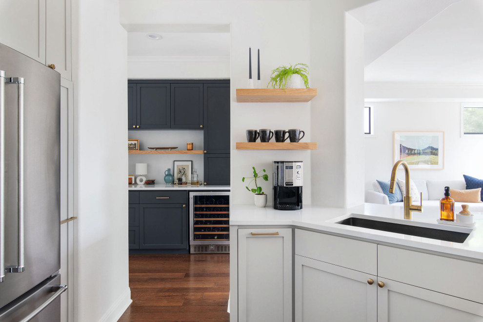 Kitchen - mid-sized transitional medium tone wood floor and brown floor kitchen idea in Austin with an undermount sink, shaker cabinets, gray cabinets, quartz countertops, white backsplash, brick backsplash and white countertops