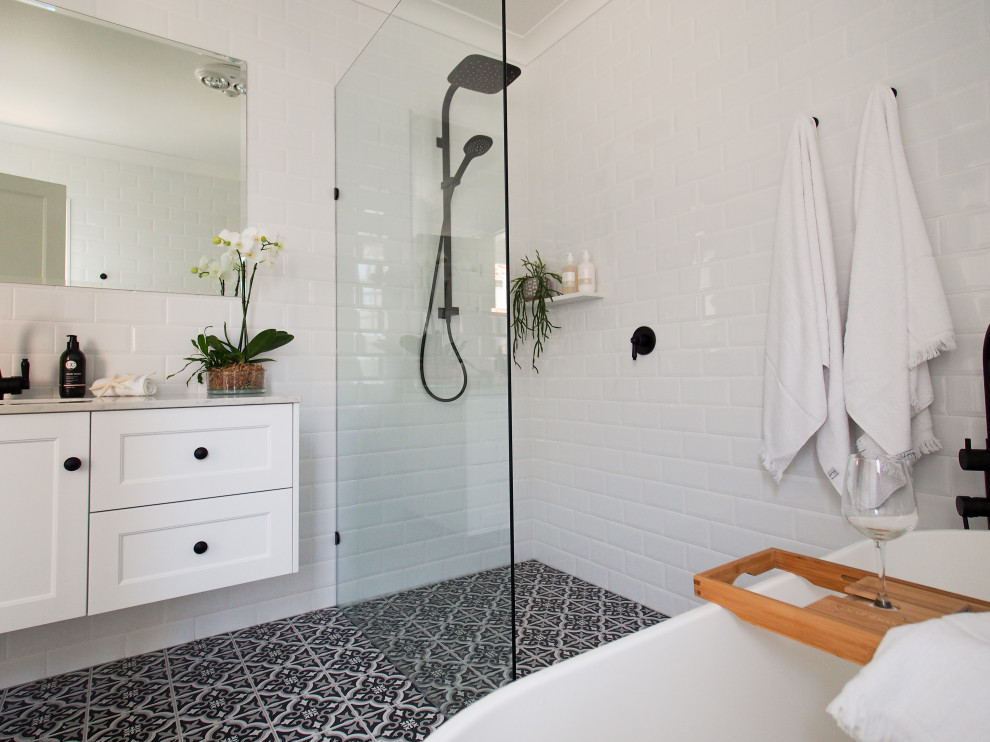 Photo of a contemporary master bathroom in Brisbane with white cabinets, a freestanding tub, an open shower, white tile, white walls, ceramic floors, marble benchtops, multi-coloured floor, an open shower, white benchtops, a single vanity and a floating vanity.
