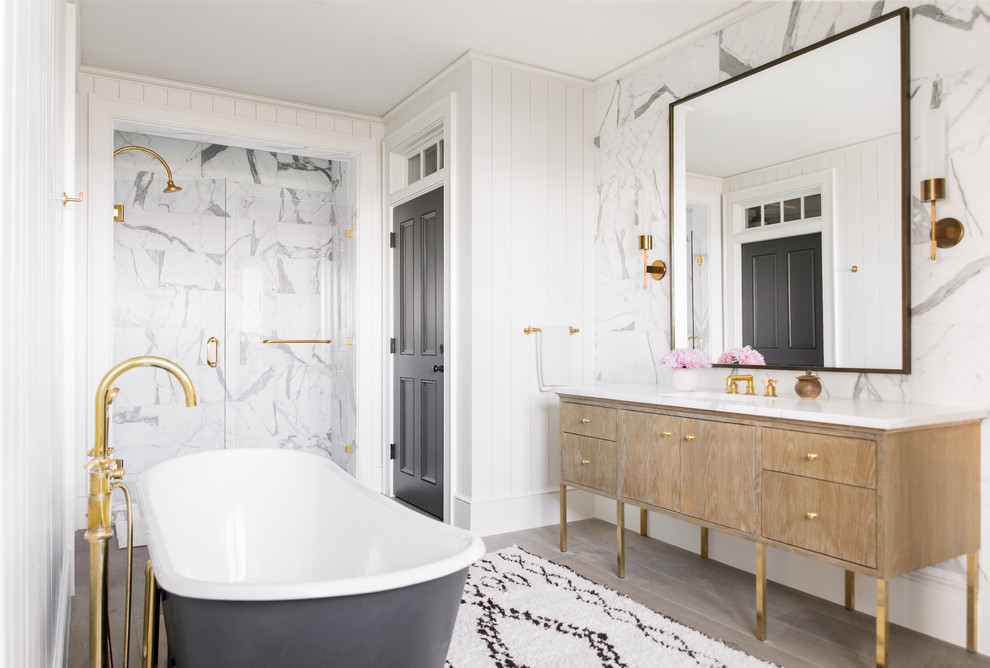 Beach style master bathroom in Charleston with light wood cabinets, an alcove shower, white tile, white walls, light hardwood floors, a hinged shower door and flat-panel cabinets.