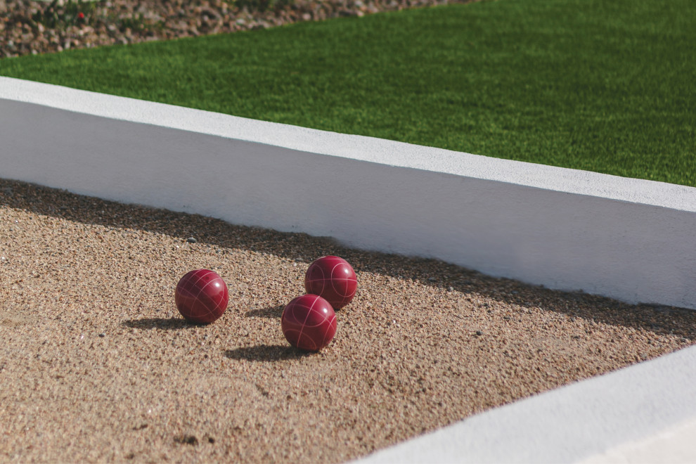 Foto di un campo sportivo esterno minimal dietro casa con uno spazio giochi e pavimentazioni in pietra naturale