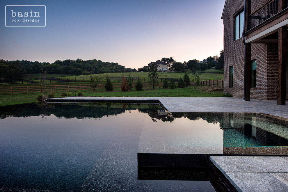 Large transitional backyard stone and custom-shaped infinity hot tub photo in Nashville