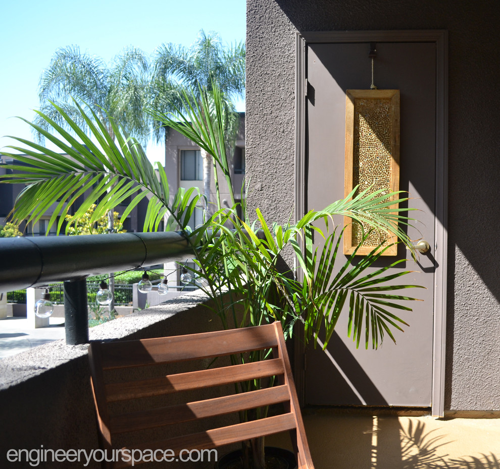 This is an example of a small tropical patio in Los Angeles with a roof extension.