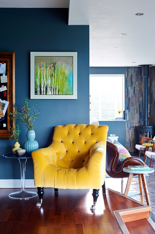 This is an example of a contemporary open concept living room in London with blue walls.