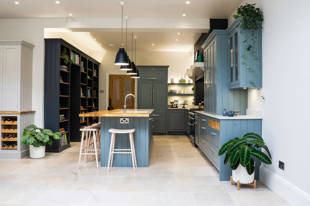 This is an example of a large traditional u-shaped eat-in kitchen in Hampshire with shaker cabinets, blue cabinets, quartzite benchtops, white splashback, glass tile splashback, panelled appliances, limestone floors, with island, white floor, white benchtop and coffered.