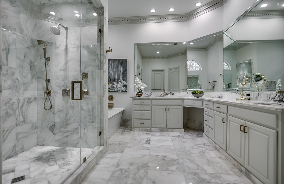 Inspiration for a large contemporary master bathroom in Dallas with raised-panel cabinets, white cabinets, a freestanding tub, an alcove shower, gray tile, white tile, marble, grey walls, marble floors, an undermount sink, marble benchtops, grey floor and a hinged shower door.