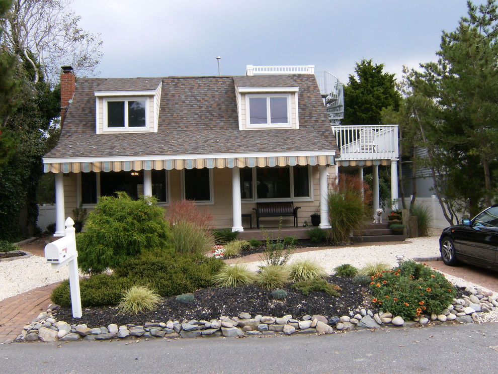 Photo of a small beach style two-storey exterior in New York with wood siding.