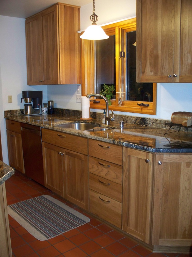 Example of a mid-sized mountain style l-shaped ceramic tile eat-in kitchen design with an undermount sink, shaker cabinets, light wood cabinets, granite countertops, multicolored backsplash, stone slab backsplash, stainless steel appliances and white walls