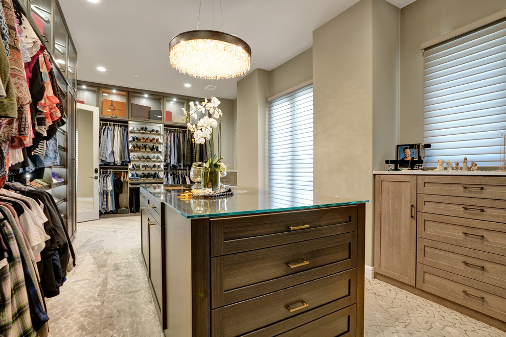 This is an example of a mid-sized contemporary gender-neutral walk-in wardrobe in Orange County with shaker cabinets, medium wood cabinets, carpet and beige floor.