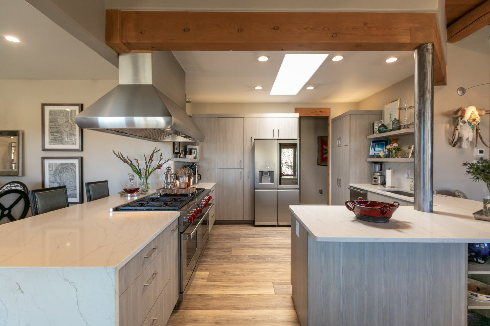 Contemporary u-shaped open plan kitchen in Albuquerque with flat-panel cabinets, grey cabinets, quartzite benchtops, white splashback, stainless steel appliances, vinyl floors, multiple islands, multi-coloured floor and white benchtop.
