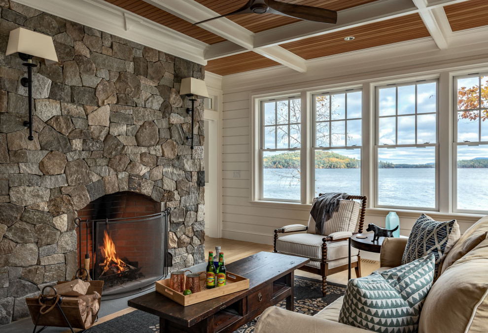 Elegant light wood floor, beige floor, coffered ceiling, wood ceiling and shiplap wall living room photo with white walls, a standard fireplace and a stone fireplace