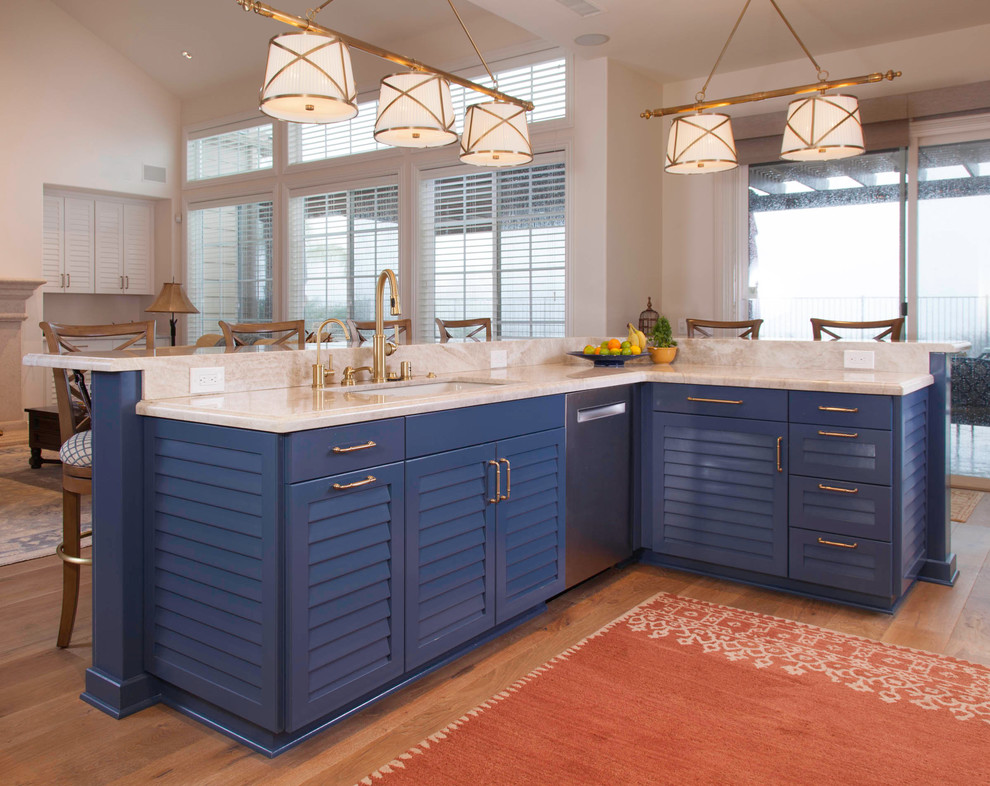 Design ideas for a mid-sized beach style single-wall eat-in kitchen in San Diego with louvered cabinets, white cabinets, marble benchtops, white splashback, marble splashback, stainless steel appliances, light hardwood floors, with island, brown floor and white benchtop.