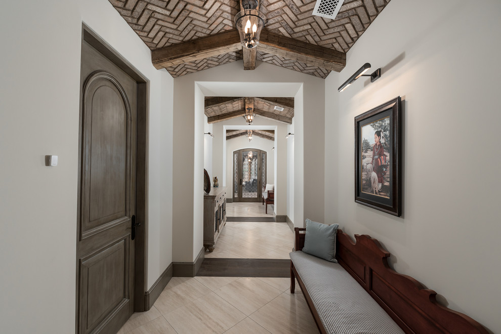 Inspiration for an expansive country hallway in Phoenix with white walls, dark hardwood floors, multi-coloured floor and exposed beam.