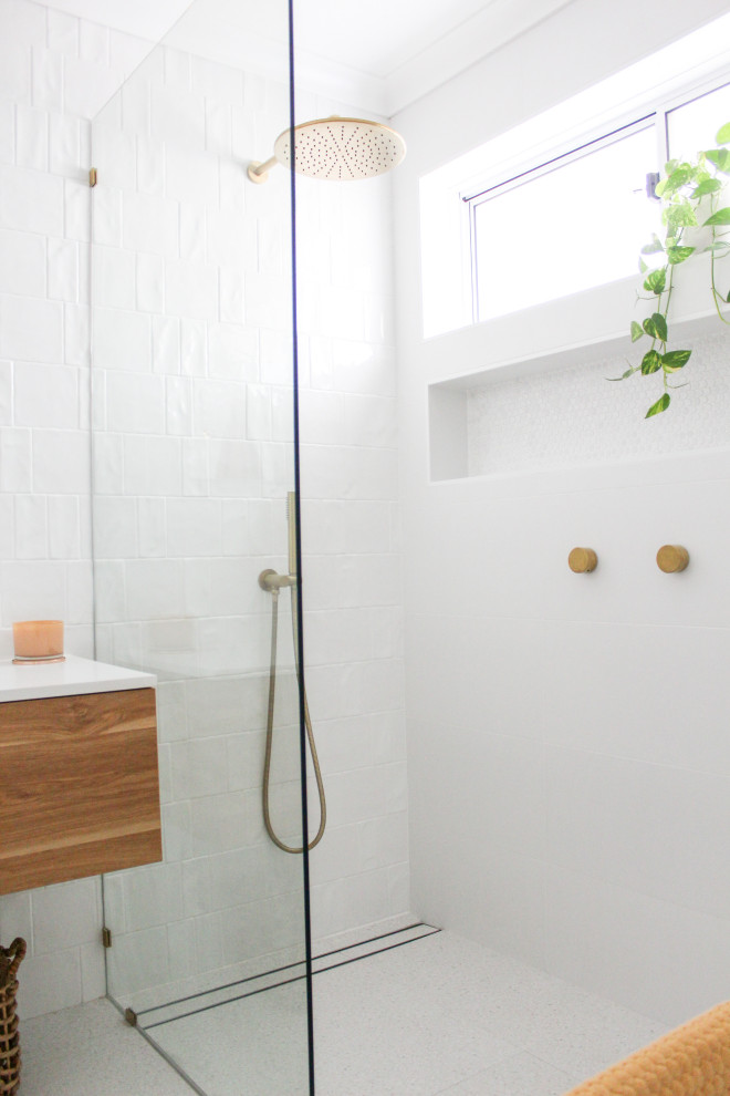 Modern inredning av ett mellanstort vit vitt en-suite badrum, med släta luckor, skåp i ljust trä, ett fristående badkar, våtrum, vit kakel, keramikplattor, vita väggar, klinkergolv i porslin, ett fristående handfat, bänkskiva i kvarts, grått golv och med dusch som är öppen