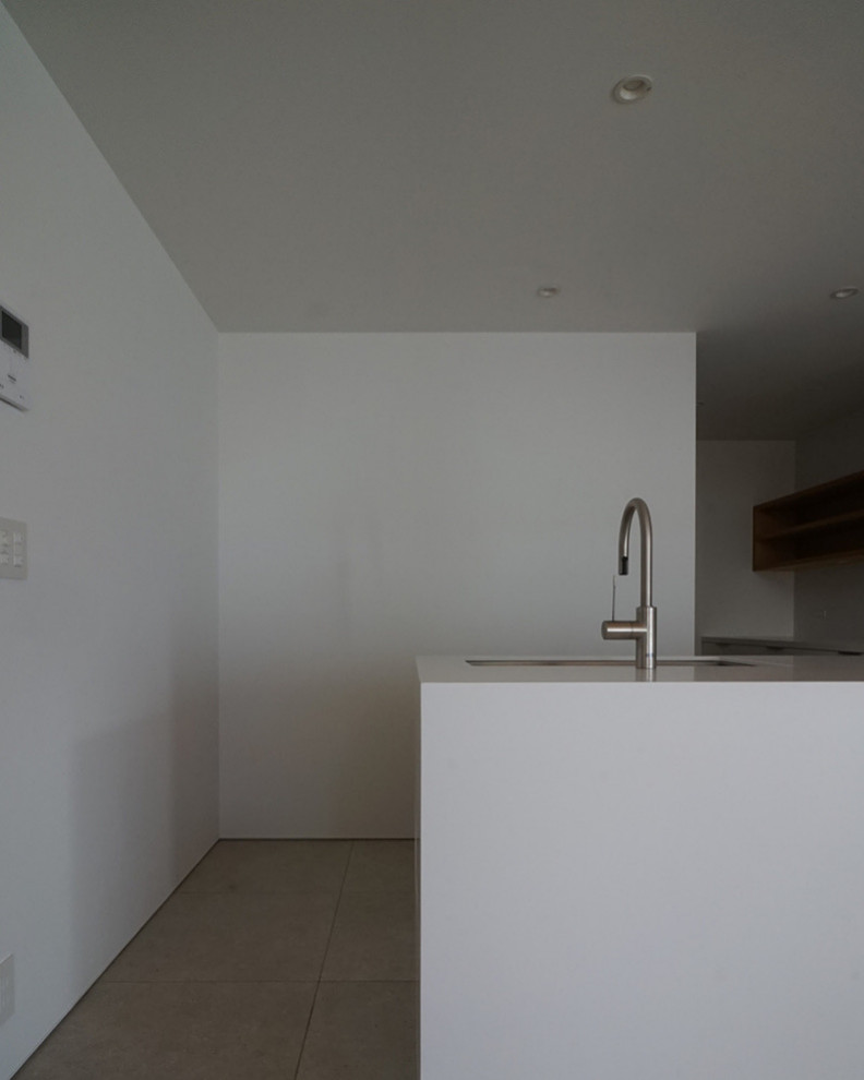 This is an example of a l-shaped open plan kitchen in Tokyo Suburbs with a submerged sink, white cabinets, composite countertops, white splashback, porcelain splashback, stainless steel appliances, cement flooring, grey floors, white worktops and a wallpapered ceiling.