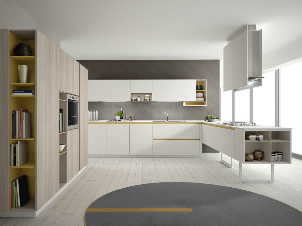 Photo of an expansive contemporary open plan kitchen in Milan with a drop-in sink, flat-panel cabinets, white cabinets, grey splashback, stainless steel appliances and light hardwood floors.