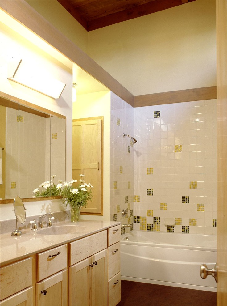 This is an example of a small retro ensuite bathroom in San Francisco with shaker cabinets, light wood cabinets, an alcove bath, a shower/bath combination, a two-piece toilet, yellow tiles, glass tiles and yellow walls.