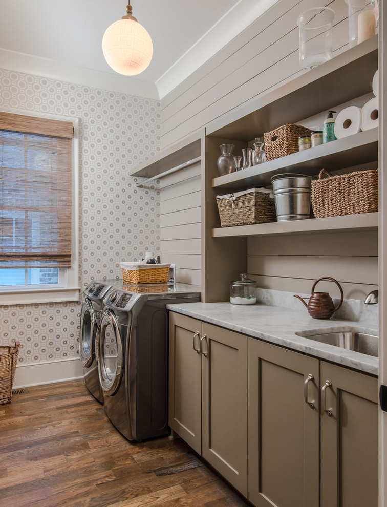 Country single-wall dark wood floor and brown floor dedicated laundry room photo in Nashville with an undermount sink, brown cabinets, a side-by-side washer/dryer, shaker cabinets and gray walls