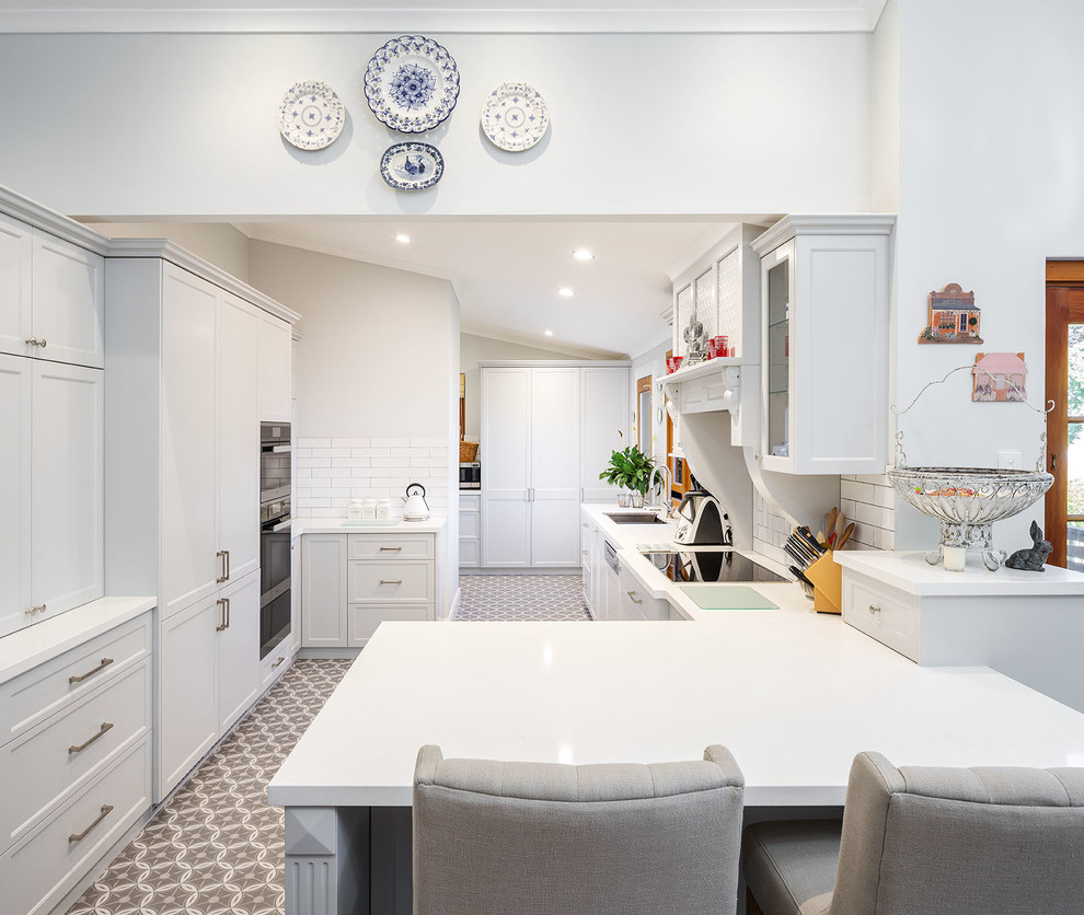 This is an example of a traditional kitchen in Perth with shaker cabinets, grey cabinets, quartz benchtops, white splashback, subway tile splashback and white benchtop.