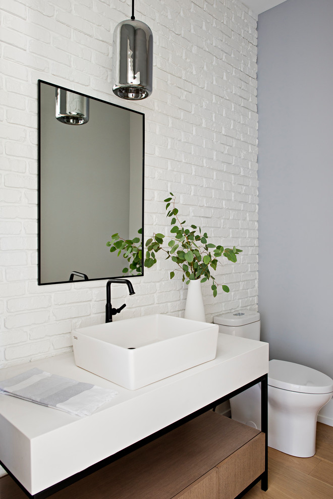 Design ideas for a transitional powder room in Toronto with white walls, a vessel sink, white benchtops, a freestanding vanity and brick walls.