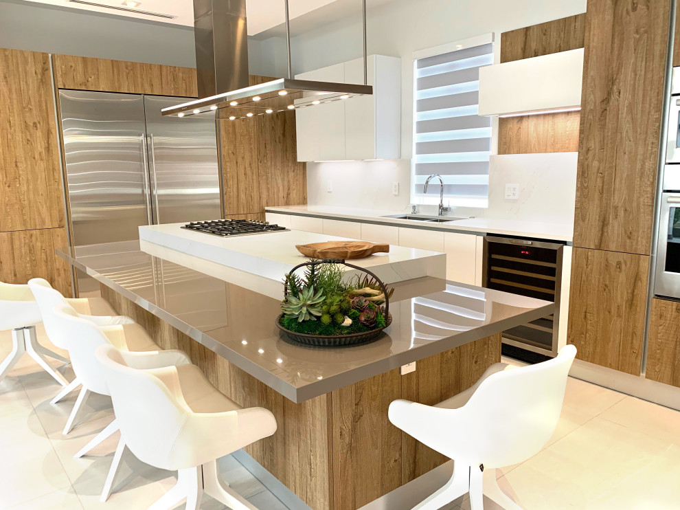 Design ideas for a mid-sized modern galley eat-in kitchen in Miami with a double-bowl sink, flat-panel cabinets, medium wood cabinets, quartz benchtops, white splashback, slate splashback, stainless steel appliances, porcelain floors, with island, beige floor and white benchtop.