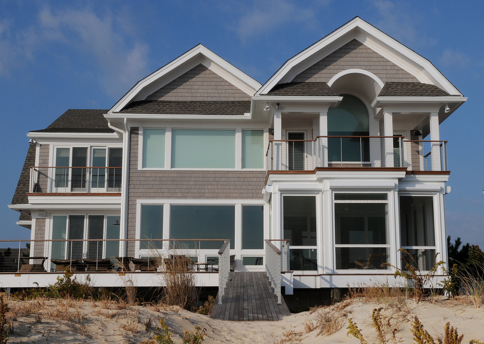 Photo of a beach style two-storey grey exterior in Other with wood siding.